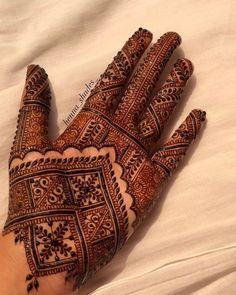 a henna on someone's hand with intricate designs