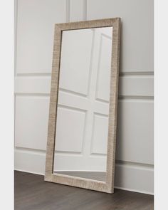 a large mirror sitting on top of a floor next to a wooden flooring board