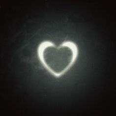 a heart shaped object is projected in the dark