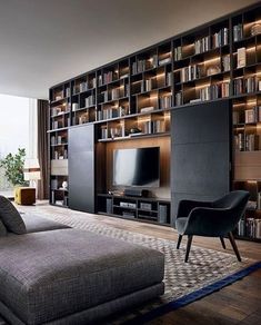 a living room filled with lots of furniture and bookshelves