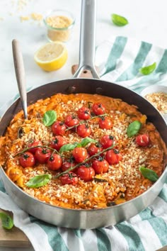 a pan filled with pasta and cherry tomatoes