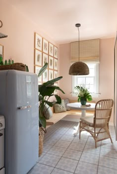 a kitchen with a refrigerator, table and chairs in the corner next to a window