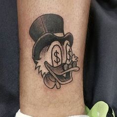 a tattoo on the leg of a person wearing a top hat