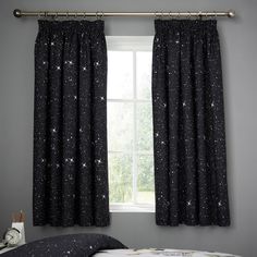 a bedroom with black curtains and stars on it