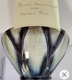 a black and white vase with writing on the bottom that says, black adventure over honey fux