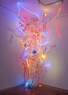 an abstract sculpture is lit up with neon lights