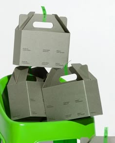 several boxes are stacked on top of each other in a green trash can with the lid open