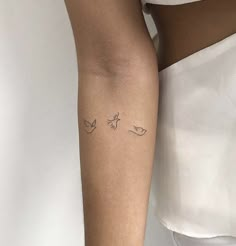 a woman's arm with two small birds on the left side of her arm