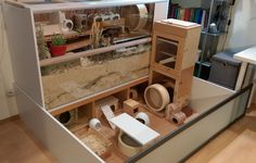 a model of a house made out of wood and various objects on display in a room