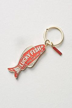 a red fish shaped keychain with the words luckyfish on it's side