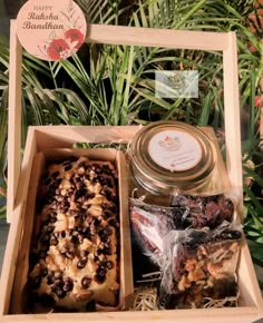 a wooden box filled with lots of different types of food next to some plant life