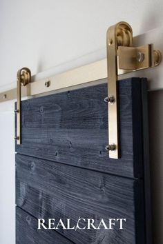 a close up of a wooden door with brass hardware on it and the words realcraft above it