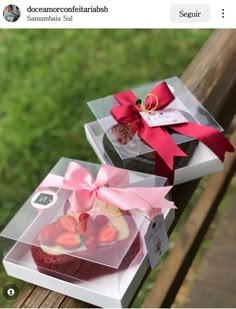 two boxes filled with cakes sitting on top of a wooden table next to each other