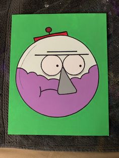 a green and purple square with a cartoon character on it's face in front of a black background