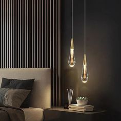 three lights hanging over a bed in a room with black walls and wooden slats