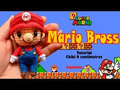 a hand holding a small crocheted mario bros doll