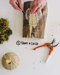 a person cutting up some wood with scissors and twine on the table next to it