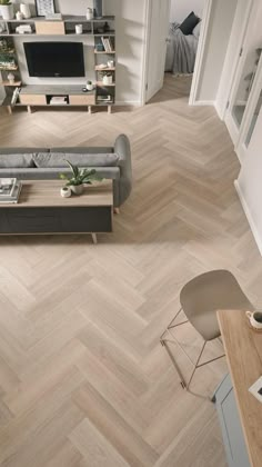 an aerial view of a living room with wood flooring and modern furniture in the background