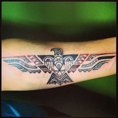 a tattoo on the arm of a man with an eagle and geometric pattern in it