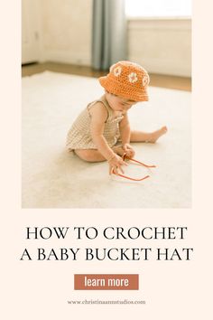 a baby sitting on the floor wearing a crochet hat with text overlay reading how to crochet a baby bucket hat learn more