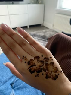 a woman's hand with a flower tattoo on it