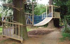 a wooden swing set next to a tree