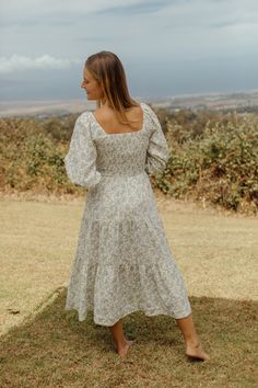 This charming dress is rich in character. Adorned with a smocked square neckline and a tiered cascading skirt. Every detail brings delight. The subtle floral  pattern resembles the oncoming tones of Fall.  XS: 46” length / 24” unstretched 40” stretched Bust / 22” unstretched 38” stretched Waist S: 46” length / 25” unst