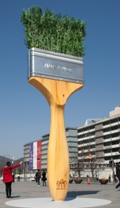 there is a planter on top of a wooden structure in the middle of a plaza