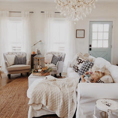 a living room filled with furniture and a chandelier hanging from the ceiling above