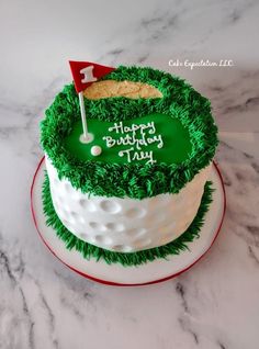 a birthday cake decorated with green grass and a golf flag on top that says happy birthday to you