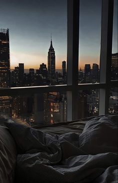 a bedroom with a view of the city at night