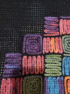 there is a crocheted blanket with many squares in the center and one square at the bottom