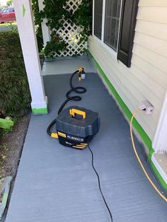 a black and yellow vacuum is on the porch