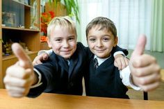 two young boys giving thumbs up at the camera