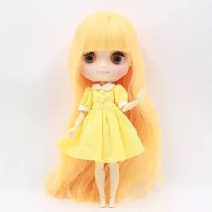 a doll with long blonde hair wearing a yellow dress and holding her hand out to the side