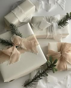 four wrapped presents with bows and pine needles