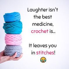 a person holding several skeins of yarn in front of a sign that says laughter isn't the best medicine crochet is