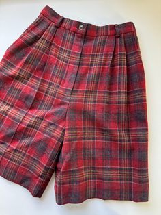 "Vintage 1970s Pendleton plaid high rise wool trouser shorts.  Great vintage condition. No notable flaws.  Marked size women's 4. See measurements below to ensure fit.  Keep in mind these are high rise and sit at narrowest part of the waist and are measured flat and how they lay naturally. Waist across laid flat: 11.75\" Hips across laid flat, below zipper: 20\" Inseam: 8.5\" Front rise: 12.5\" Thigh laid flat: 12.75\" Leg opening across laid flat: 11.5\"" Classic Short Wool Bottoms, Red Knee-length Bottoms For Fall, High Waist Red Shorts For Fall, Plaid Short Bottoms For Fall, Vintage Knee-length Winter Bottoms, Vintage Knee-length Bottoms For Winter, Fall Plaid Shorts, Vintage Plaid Bottoms For Work, Vintage High Waist Plaid Bottoms