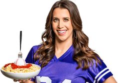 a female football player holding a plate of spaghetti