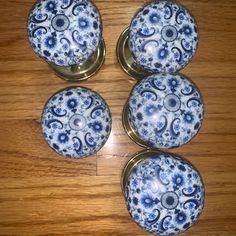 four blue and white knobs on a wooden surface