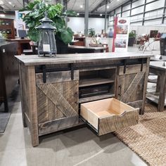 a table with drawers and a lamp on it in a room filled with furniture, rugs and other items