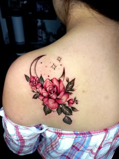 the back of a woman's shoulder with roses and a crescent tattoo on it