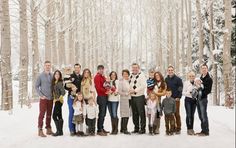 a group of people posing for a photo in the snow with trees and snow covered ground