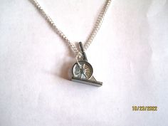 a silver necklace with a small clock on it