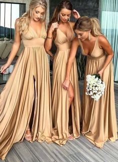 three bridesmaids in gold dresses with one holding a bouquet and the other looking at her