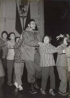 a man standing on top of a wooden floor next to children in front of him