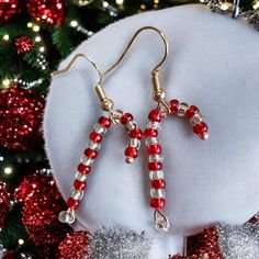 Sweet candy cane novelty earrings. Hand made with silver lined glass beads and mounted on gold plated ear wires. Available in red or gold. Approx drop 25 mm Wire Christmas Earrings, Holiday Red Beaded Earrings With Ear Wire, Red Round Beaded Earrings For Christmas, Red Round Beads Earrings For Christmas, Red Beaded Drop Earrings For Christmas, Christmas Party Earrings With Dangling Beads, Christmas Party Earrings With Round Beads, Christmas Party Round Bead Earrings, Christmas Party Round Beads Earrings