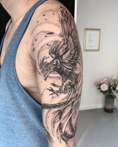 a man with a tattoo on his arm has a bird in the sky above him