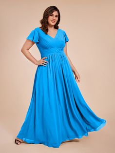 a woman in a blue dress posing for the camera with her hands on her hips