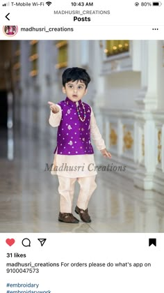 a little boy wearing a purple shirt and white pants